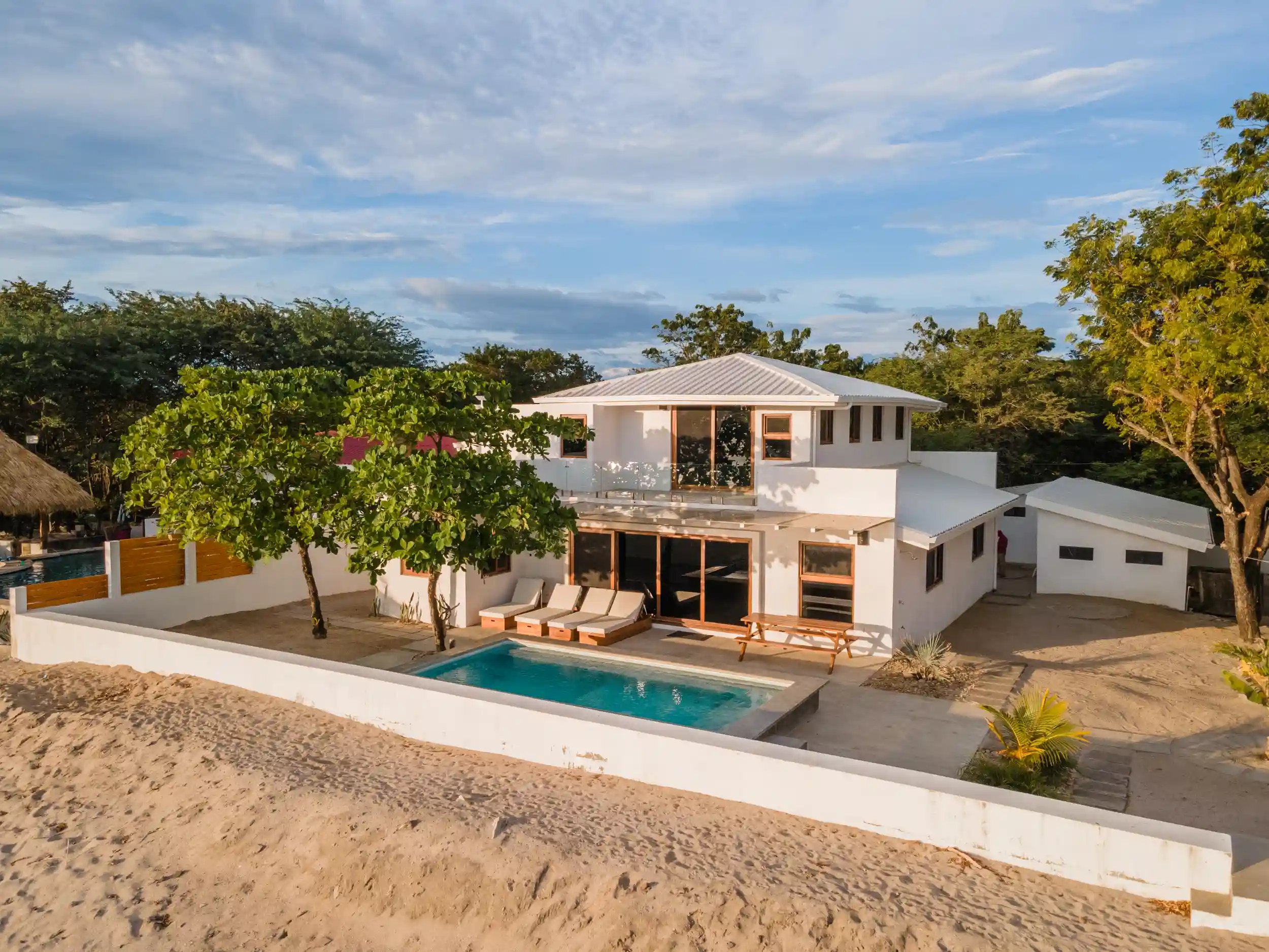 Modern two-story residential home with clean architecture, private pool, and outdoor living areas, showcasing high-quality construction and development.